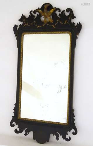 A 19thC ebonised mirror with gilt painted decoration.