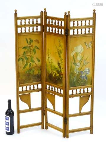 An aesthetic movement folding screen with hand painted panels and turned finial colonnades above