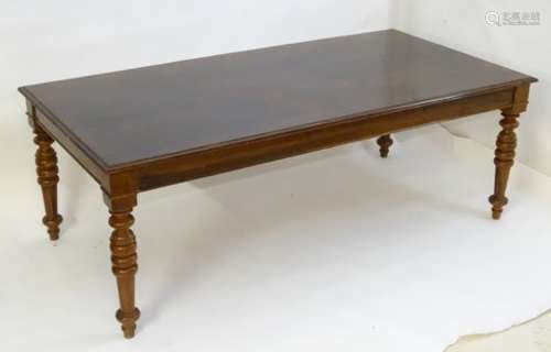 A 20thC hardwood dining table with a large rectangular top above four turned tapering legs.