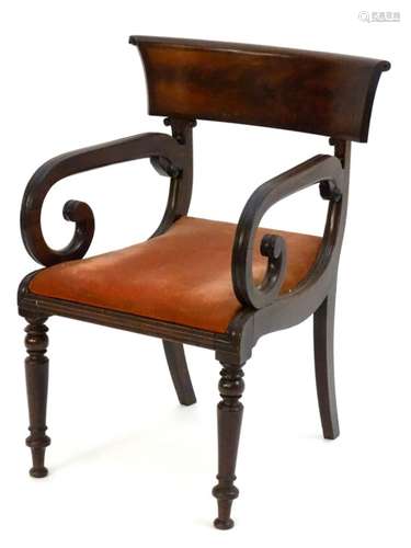 An early 19thC mahogany open armchair with a large flame mahogany top rail above scrolled reeded