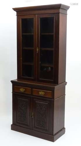 An Edwardian mahogany glazed bookcase, having a moulded cornice above two doors,