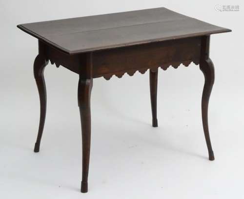 A 19thC continental walnut table with a rectangular top above a carved apron and standing on