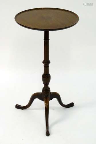 An early 20thC mahogany tripod table with a circular dished top above a tapering turned stem and