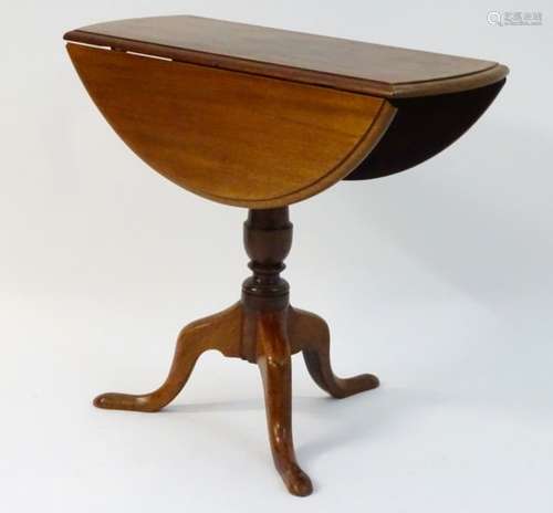 A late 19thC drop flap table standing on a pedestal base with three cabriole legs.