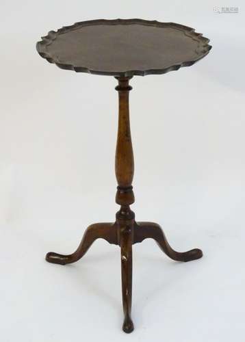 An early 19thC mahogany occasional / lamp table with a turned stem and three cabriole legs below a