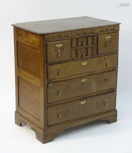 An early 18thC oak chest of drawers with a shaped frieze above two short moulded drawers flanked by