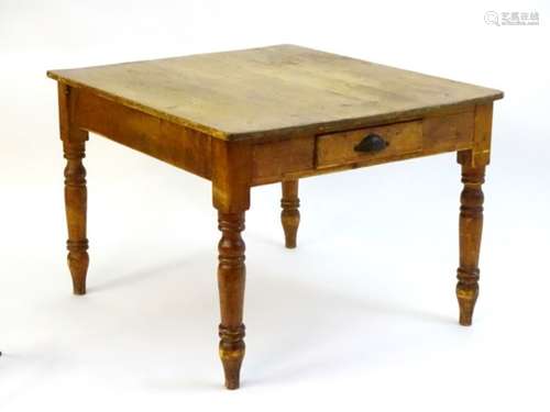 A late 19thC pine kitchen table with a single short drawer to one end and raised on turned tapering