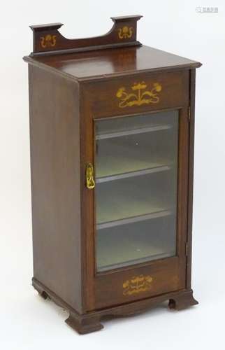 An early 20thC mahogany music cabinet with a shaped up stand decorated with marquetry detailing