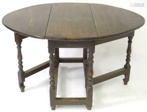 An 18thC oak gateleg table with drop leaves to each side,