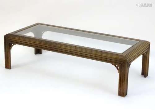 A 20thC Oriental style coffee table with a reeded frame and Chinese Chippendale style corner