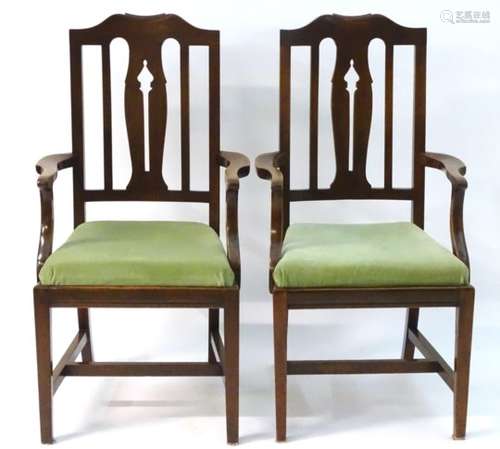 A pair of early / mid 20thC mahogany open armchairs with shaped top rails,