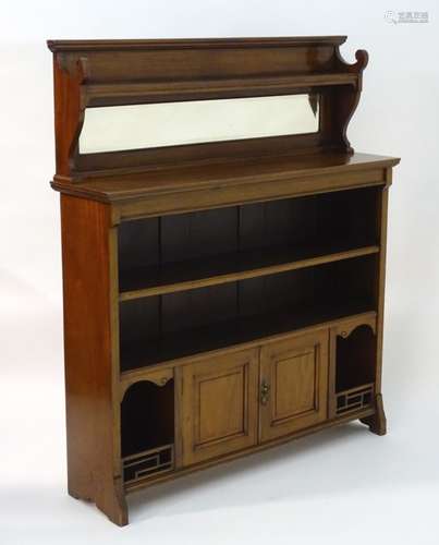 A late 19thC / early 20thC Aesthetic movement mahogany bookcase with a mirrored back having