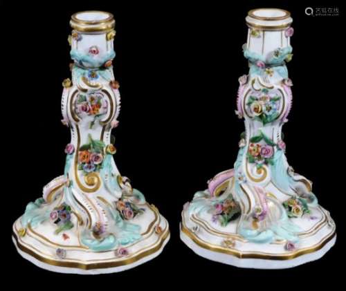 A pair of 19thC Meissen porcelain rococo candlesticks, decorated with applied flowers and