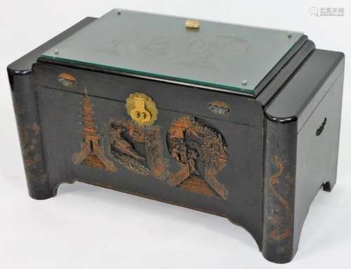 A 20thC Chinese lacquer camphor wood chest, of shaped rectangular form, the glass top revealing a