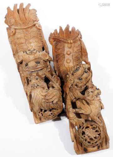 A matched pair of Chinese wooden carvings, of a dragon and young, heavily carved and picked out in
