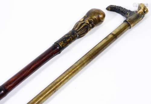 A Chinese bamboo type walking stick, with rubber end and metal top, set with a figure of a bearded