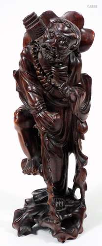 An early 20thC Chinese root carving, of a bearded sage in flowing robes holding staff in a