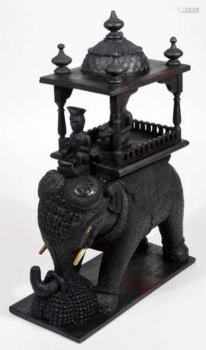 A Burmese carved wooden statue figure group, of an elephant with rider and elaborately carved top,