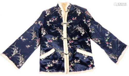 An early 20thC Japanese jacket, in silk type floral pattern, with elaborate buttons and wool lining,