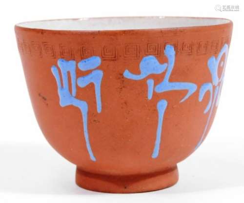 A Chinese red ware pottery tea bowl, the bell shaped body, with an upper Greek key style design,