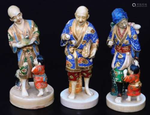 An early 20thC Japanese figure group, of a gentleman in flowing robes holding bird aside child,