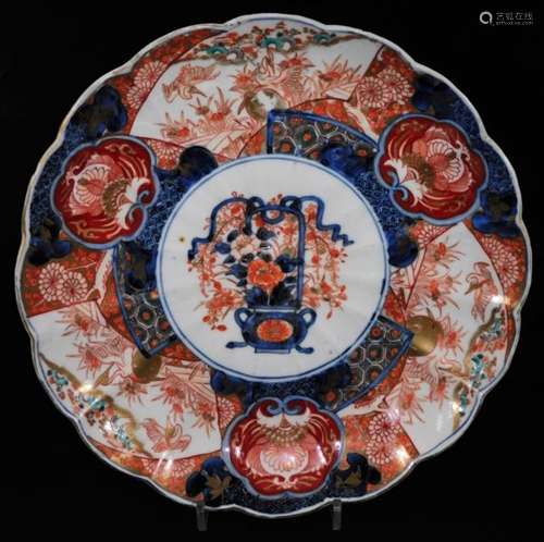 A Japanese late Meiji period porcelain Imari dish, of floral form, centred with a vase of flowers