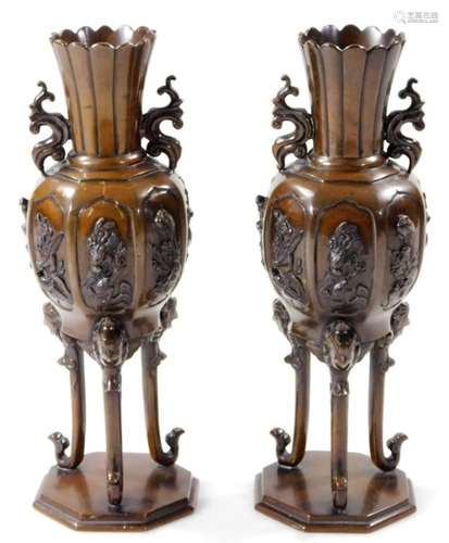 A pair of Japanese patinated bronze vases, each with floral stems flanked by S scroll handles,