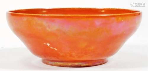 An orange glazed bowl, of shaped circular form with sagger marks beneath, unmarked, probably