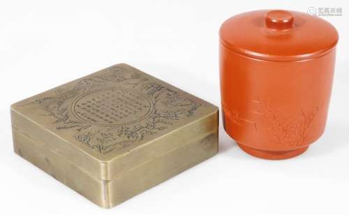 A Chinese metal box, of rounded square form set with a panel containing various characters