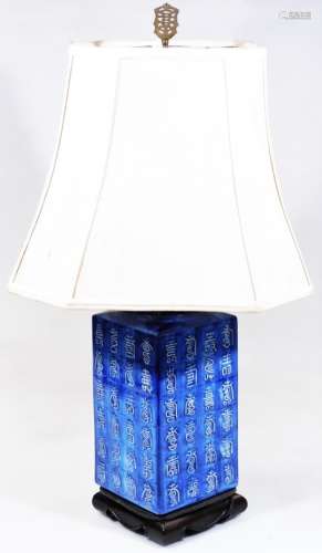 A Chinese semi porcelain table lamp, of square form set with various figures on a fixed ebonised