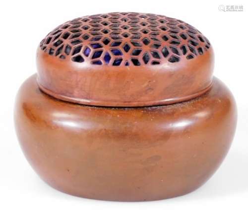 An early 20thC oriental metal potpourri jar and cover, the oval pierced lid on a plain body, with
