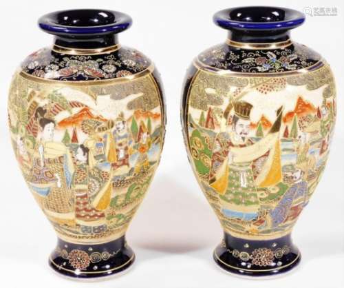 A pair of early 20thC Japanese ovoid vases, each decorated with panels of figures and raised with