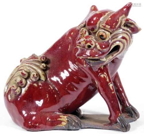 A Chinese pottery Sang De Boeuf figure, of a seated dragon, on shaped base, unmarked, 17cm H.