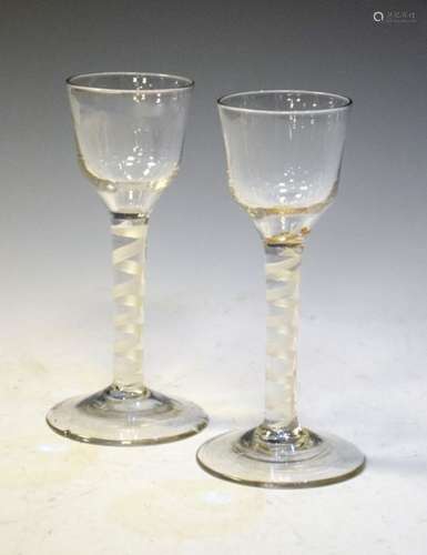 Two George III-style air-twist cordial glasses, each with rounded funnel bowl over single series