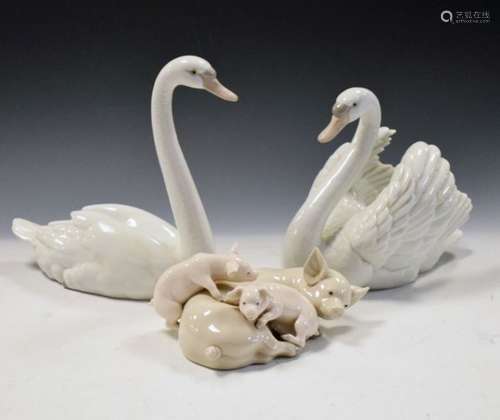 Two Lladro porcelain swans, 5230 and 5231, the first 21cm high, together with a sow and piglets (3)