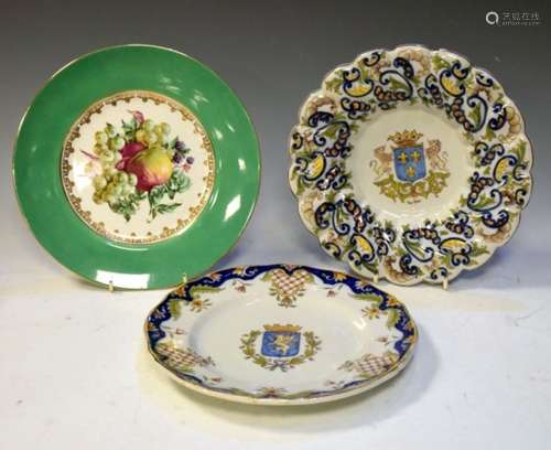 Two French faience plates with Armorial crests, largest 27cm diameter, together with a printed fruit