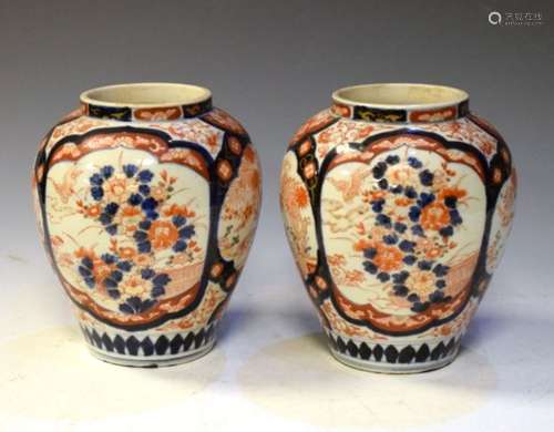 Pair of Japanese Imari baluster shape vases, each decorated with four panels of foliage, birds and