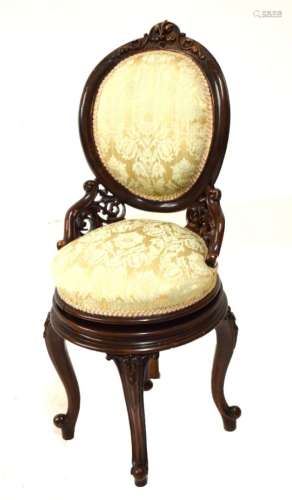 Late Victorian carved walnut adjustable revolving music chair with padded oval back having stipple-