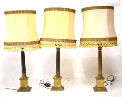 Three brass Corinthian column table lamps, to include; a pair, each of fluted form on stepped