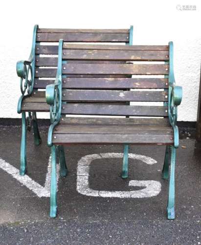 Two cast metal green painted garden seats having wooden slats