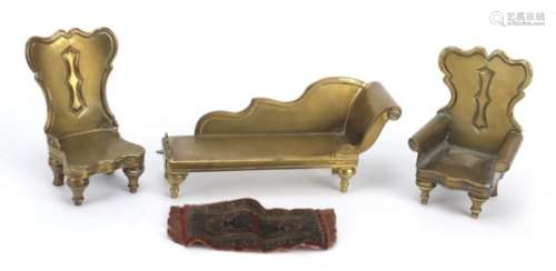 Antique brass dolls house furniture and a rug comprising two chairs and a chaise lounge, the largest