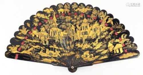 Chinese black lacquer fan gilded with figures amongst pagodas and a river landscape, 20cm in