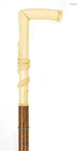 Palmwood walking stick with bone handle carved with a serpent, possibly whale bone, 97cm in length :