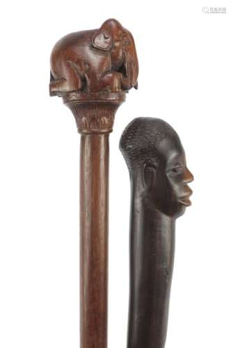 Two African walking sticks with carved elephant head and figural pommels, the largest 91cm in length