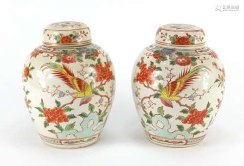 Pair of Chinese porcelain jars with covers, each hand painted with birds of paradise amongst