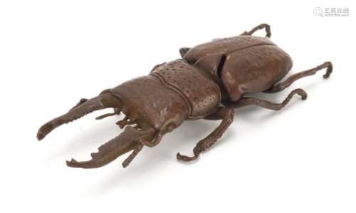 Japanese patinated bronze stag beetle with articulated wings, impressed marks to the underside, 13cm