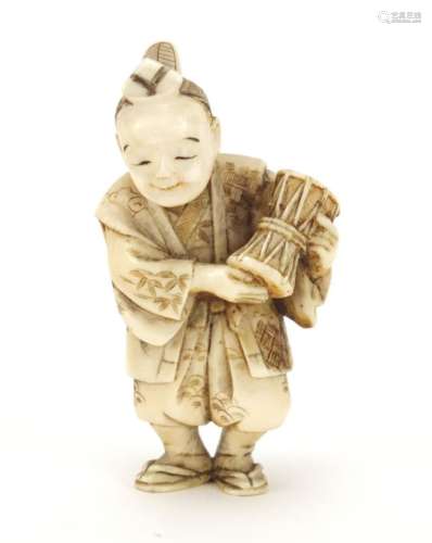 Japanese carved ivory Netsuke of a figure holding a drum, 6cm high : For Further Condition Reports