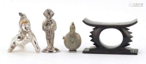Two unmarked silver Indian figures, a Tibetan scent bottle and African head rest, the largest 10cm