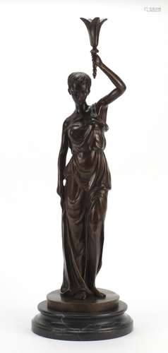 Patinated bronze study of a classical female holding a torch aloft, raised in a circular marble