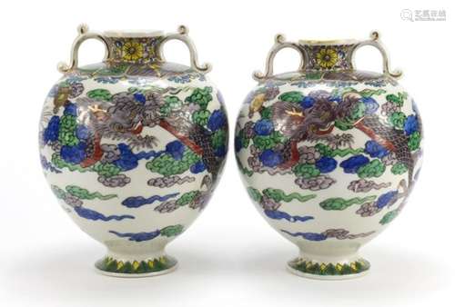 Pair of Chinese porcelain vases with twin handles, each hand painted with dragons, each 24.5cm